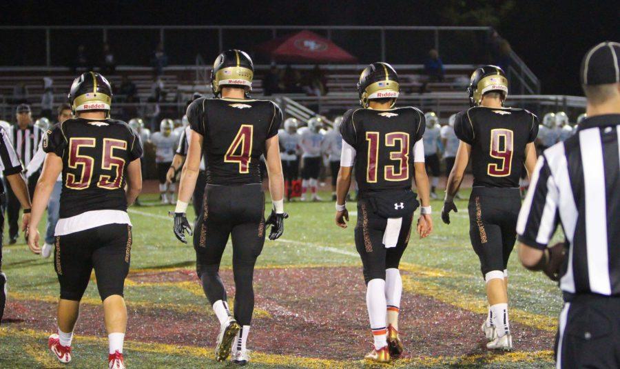 Varsity players Nate Green, Jackson Smith, Jack Fulp, and Sean Garrigan march across the field during the homecoming game.