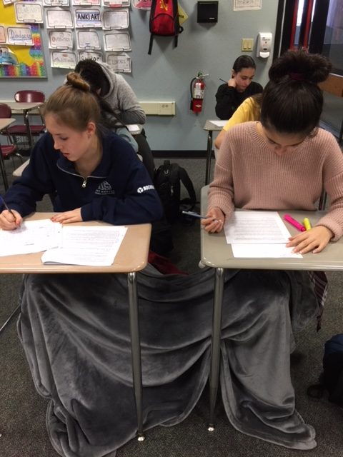 Nelmarie De Jager and Elise Garcia stay warm on Dec. 22 during their freshman English final, with Eliana Goldstein in the back right. For the first time, finals took place the three days before winter break. School is scheduled to start Aug. 16 in order for fall semester to finish in December 2018.

