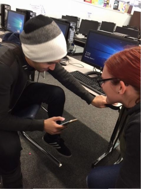 Senior Motaz Youniz and junior Regan Ruff take a break for a cell phone check-in while in the library technology center March 5.