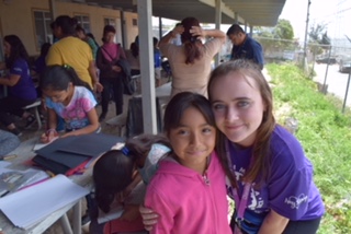 Senior Aisling Murphy visits with a child in Tijuana, Mexico, where she and other students spent spring break building homes as part of a weeklong mission.