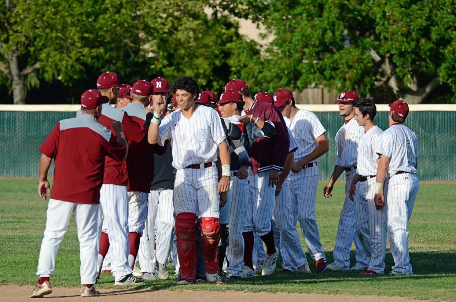 Varsity baseball celebrates on the field after a 5-3 win over College Park May 10. The game was also Senior Night., a recognition of the team's nine seniors on their last home game.
