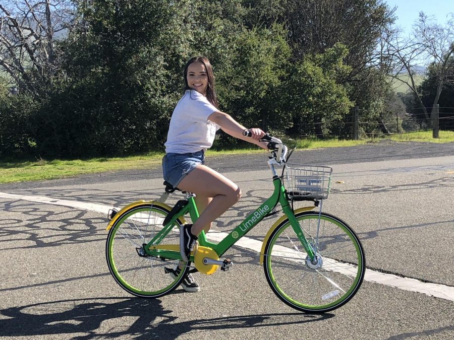 Senior Katie MacCormac rides a LimeBike around the student drop-off and pick-up zone in early February.
