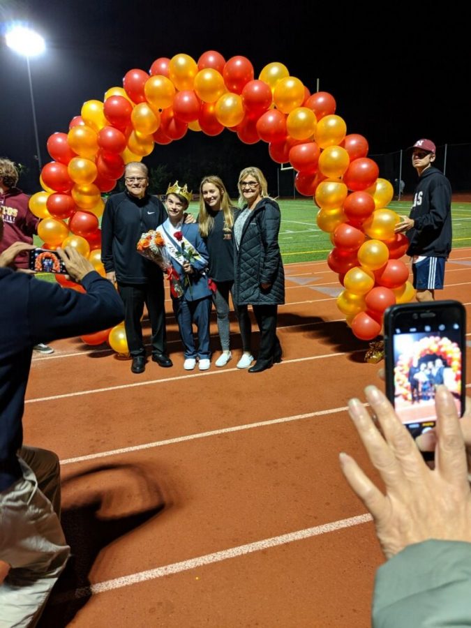 Gus Xepoleas, voted Homecoming King by his classmates, is escorted by his sophomore sister, Grace, and his parents, Thomas and Holly, at the Homecoming football game Friday Sept. 29, 2019.