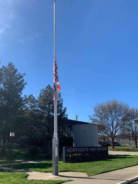 The United States and California state flags are lowered to half-staff on a breezeless Thursday Feb. 25, joining flags nationwide in memorial to those who have died of COVID-19. 