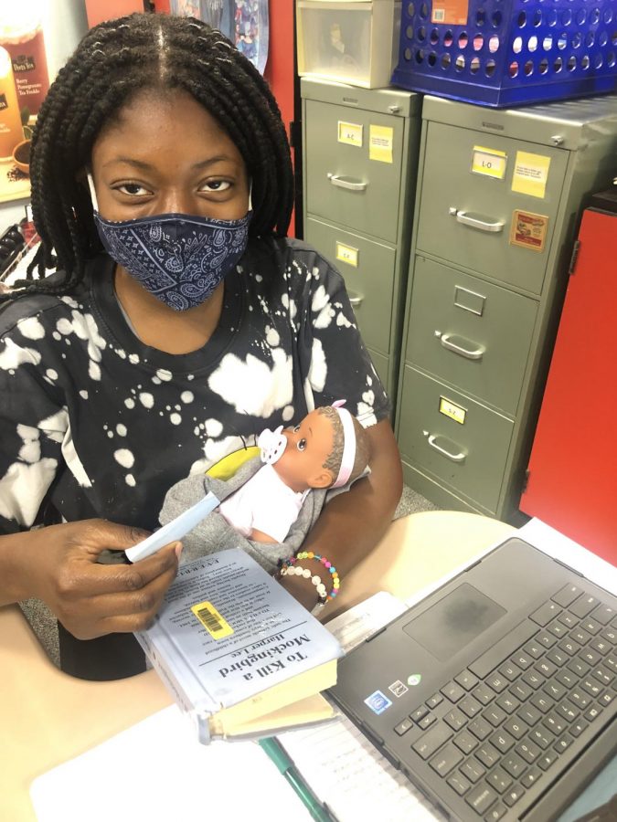 Freshman Oladunni Akinsola completes work in her English class Oct. 19 while participating in a project for her psychology class that requires students to care for a 