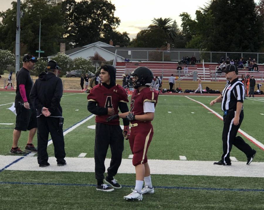 Freshman Sadie Hansell, number 2, talks with teammate David Franco, a freshman, during the Oct. 8 game against Berean High School where she made several tackles. Hansell plays defensive back, safety, and corner.