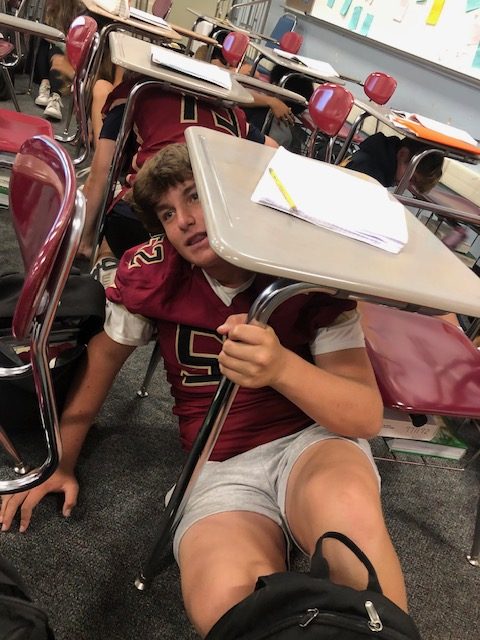 Freshman+Brennan+Berger+and+other+classmates+duck+under+desks+during+their+English+class+for+the+Oct.+19+earthquake+drill.+The+drill%2C+part+of+national+ShakeOut+Day%2C+occurred+one+day+after+students+felt+a+real+quake.