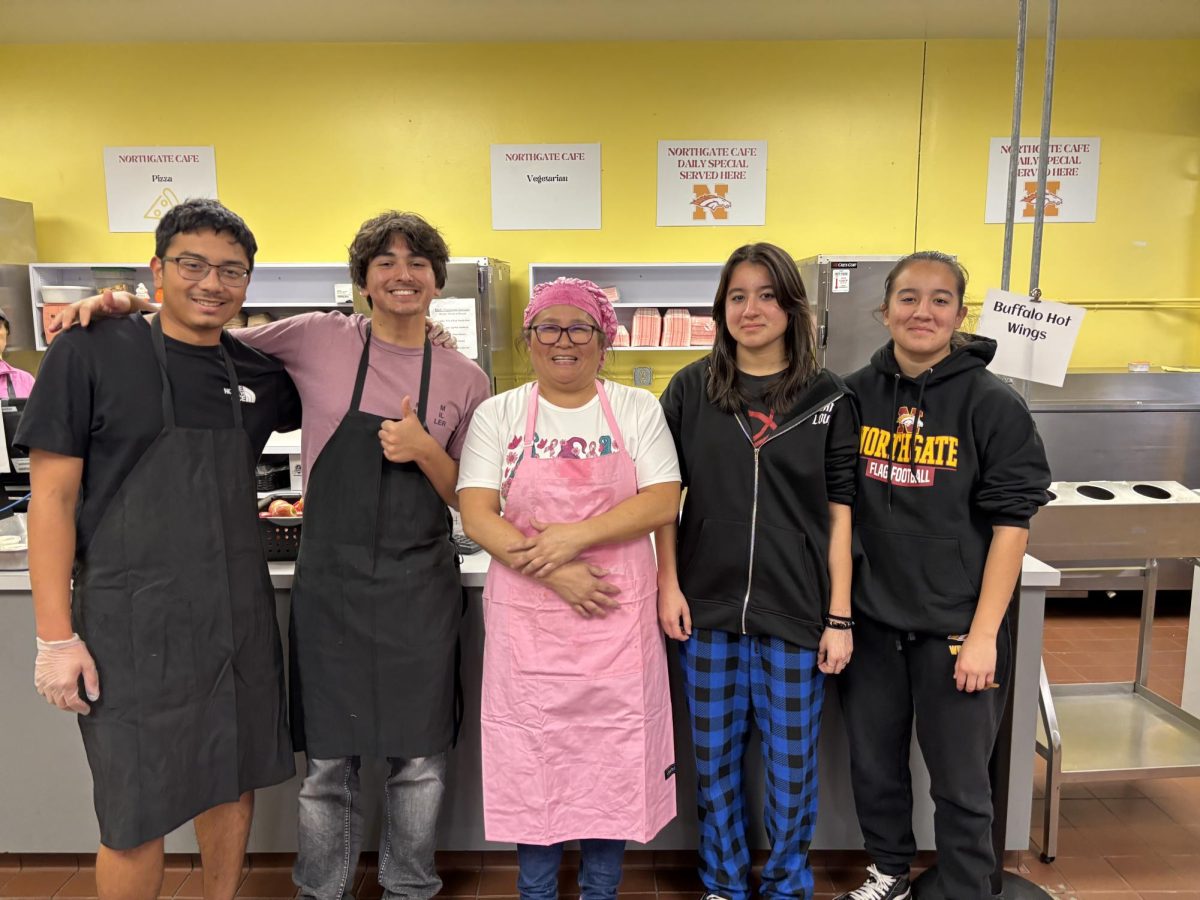 (From left to right, senior Ramon Iniguez, senior Ethan Parks, cafeteria manager Shelley Carmichael, junior Minna Hill, and junior Nadia Hill take a break after serving up hundreds of lunches on a busy day in November.